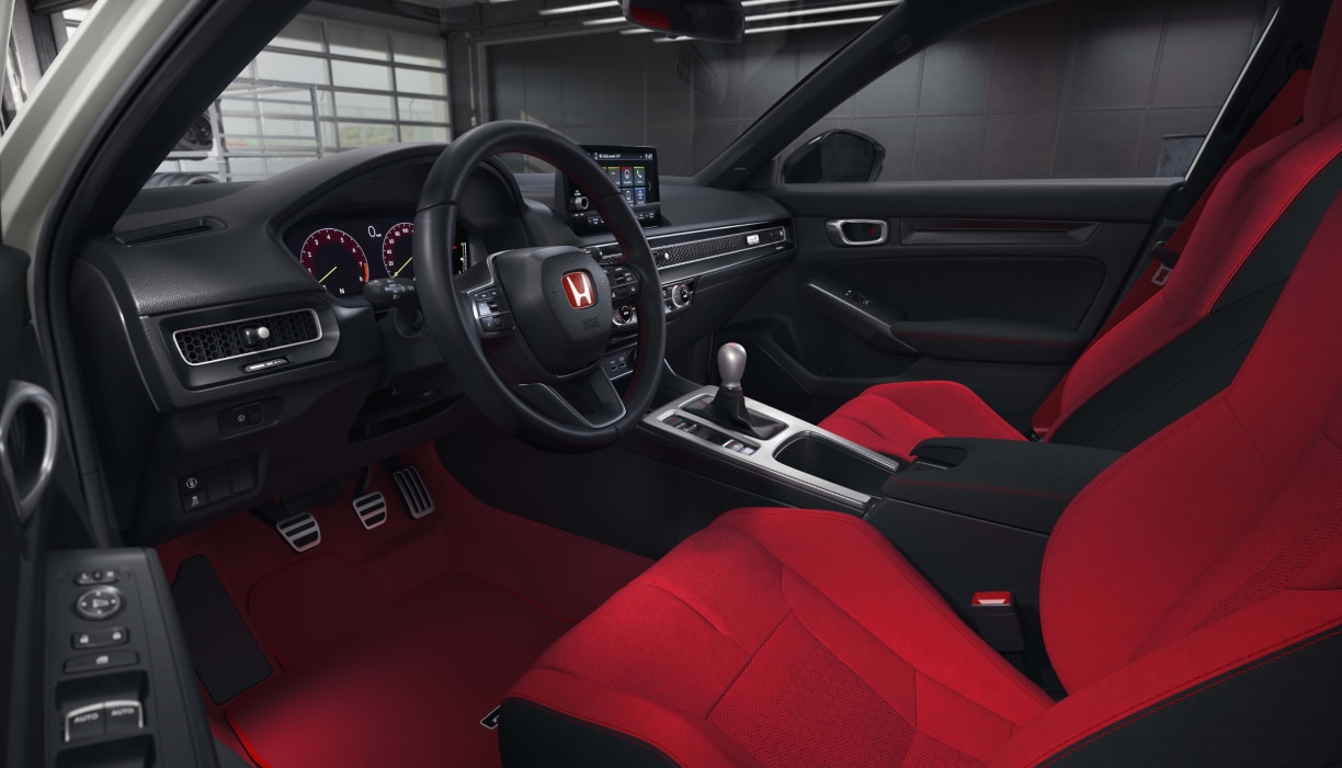 Wide shot of the cockpit, showcasing the red bucket sport seats and entire front dashboard.