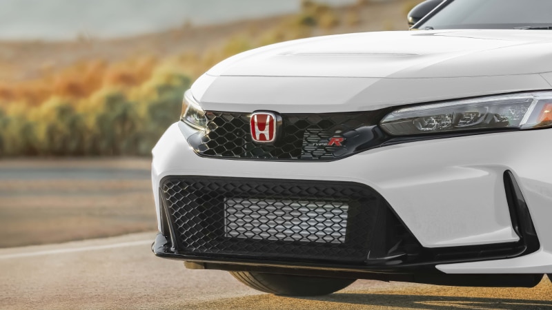 Gros plan de trois quarts d’un logo « Honda » rouge et d’un emblème « Type R » sur une Type R rouge.