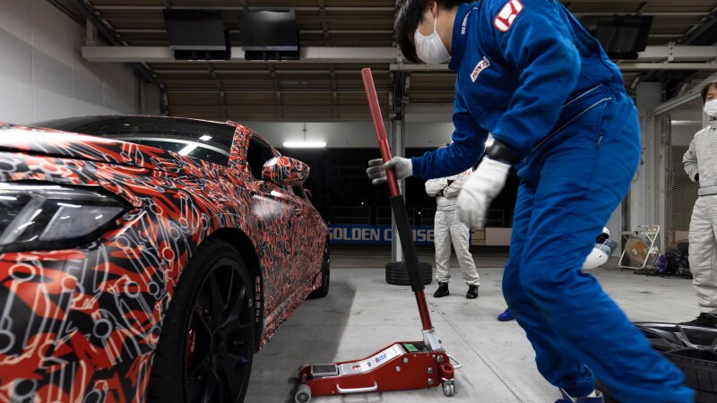 Une Type R avec peinture rouge géniale et monogrammes Type R dans un garage sur le point d’être levée avec un cric.
