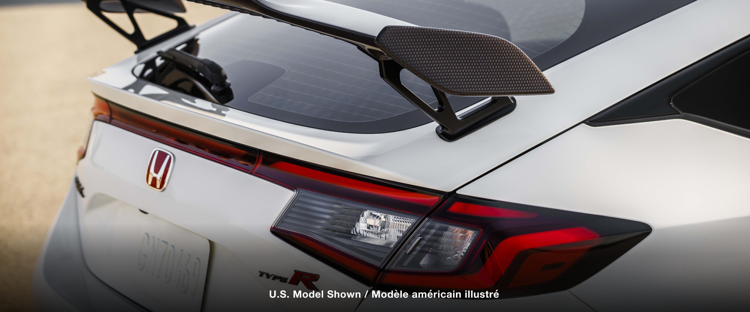 3/4 closeup of white Type R’s rear wing spoiler.