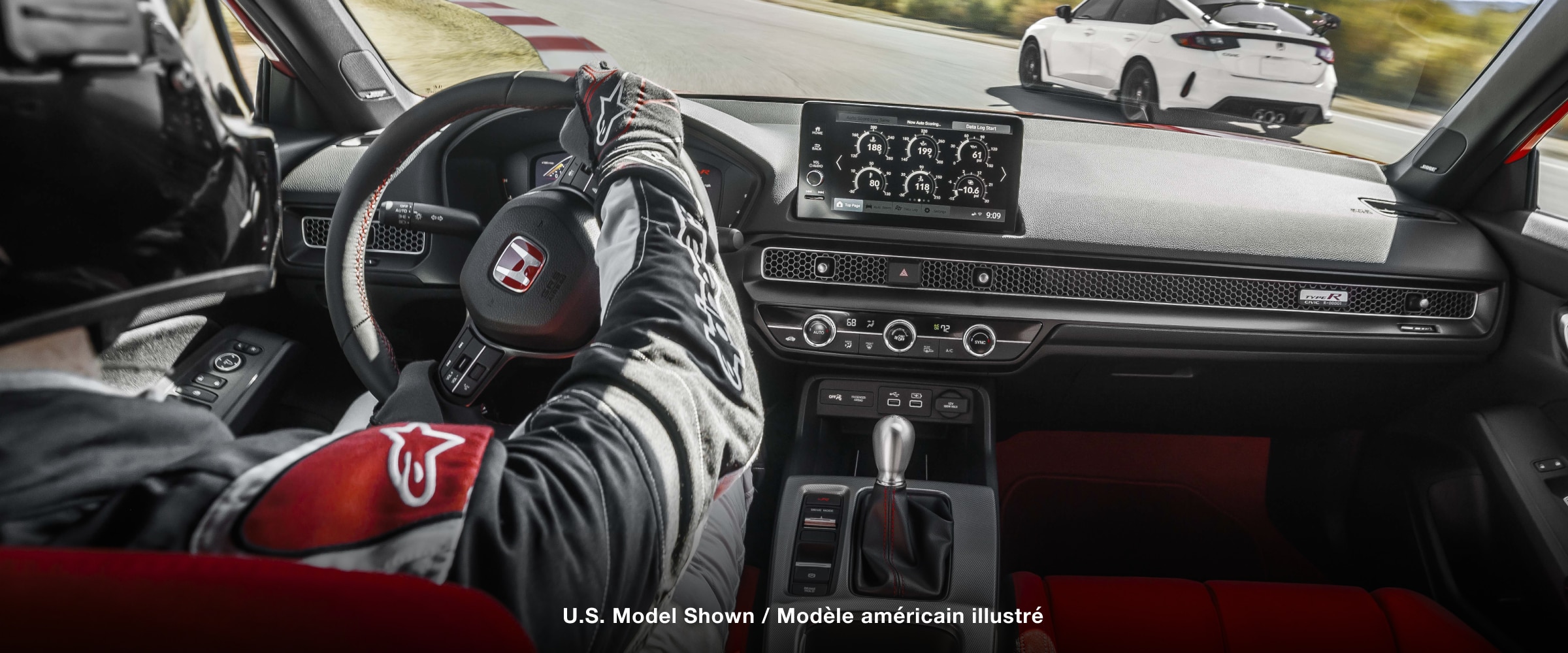 Interior shot, over pilot’s shoulder, showcasing the Type R’s cockpit as it races on a track.