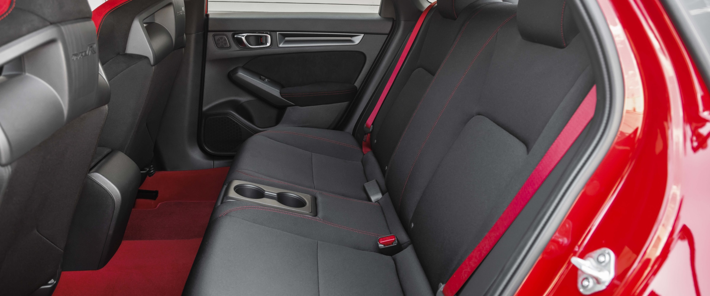 Vue latérale des sièges arrière d’une Type R rouge.