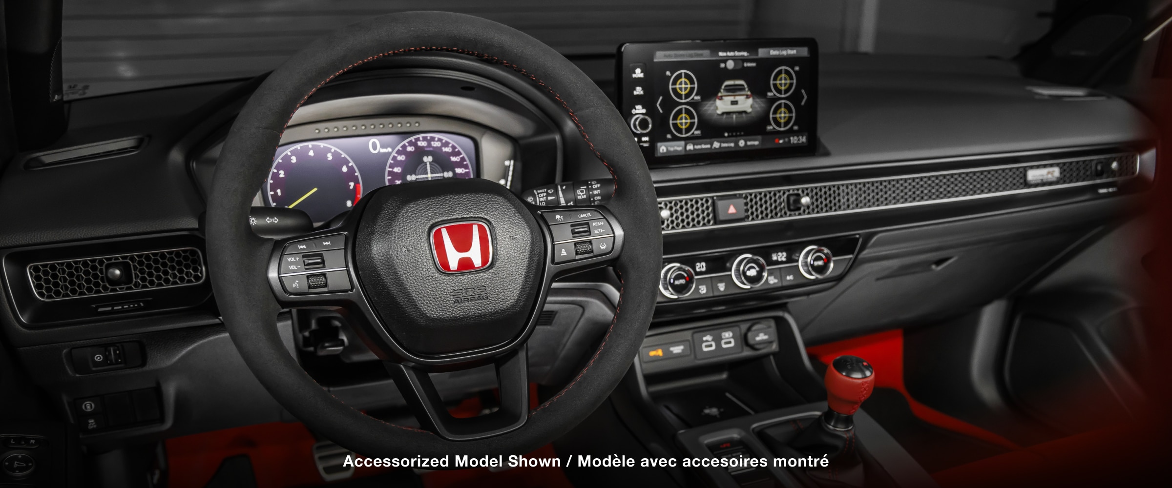 Medium closeup of steering wheel, dashboard, centre console, and gear shifter.