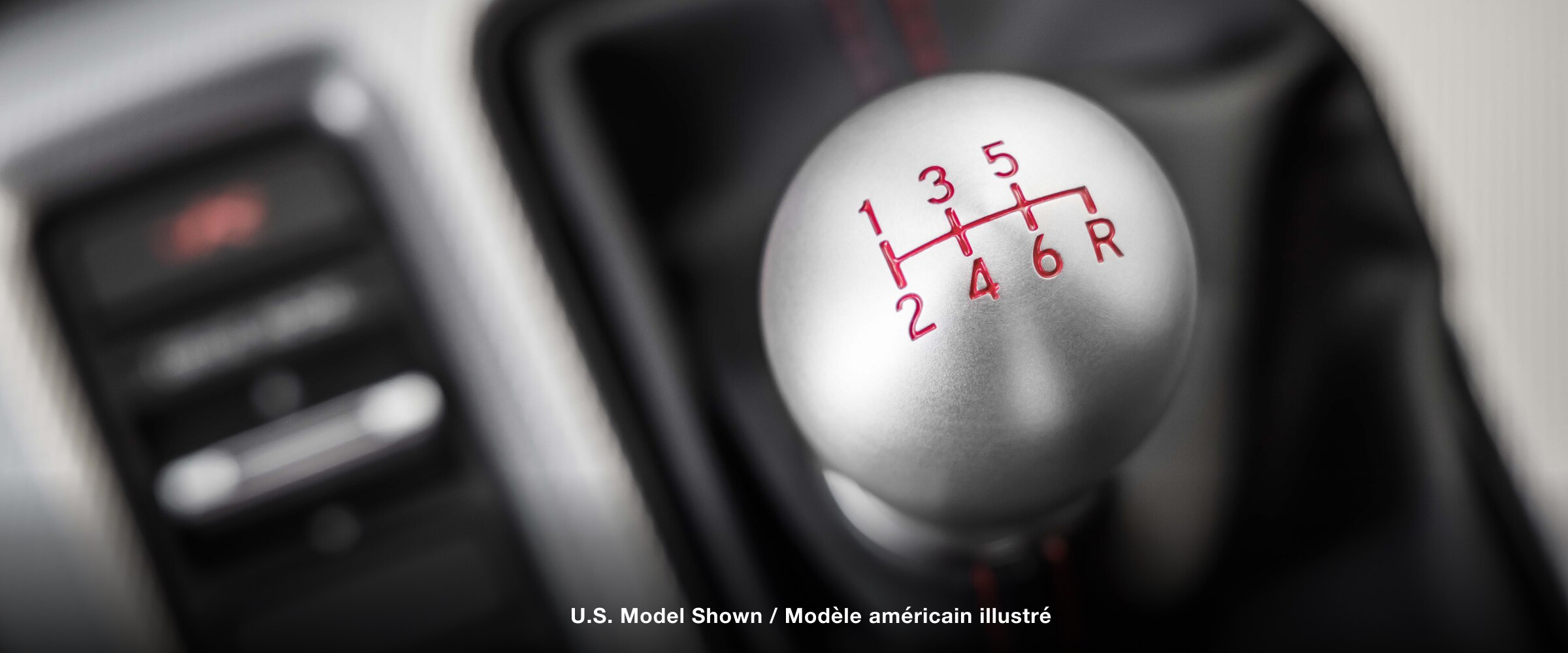 Très gros plan du haut du levier de vitesses, affichant la grille des vitesses engravées.