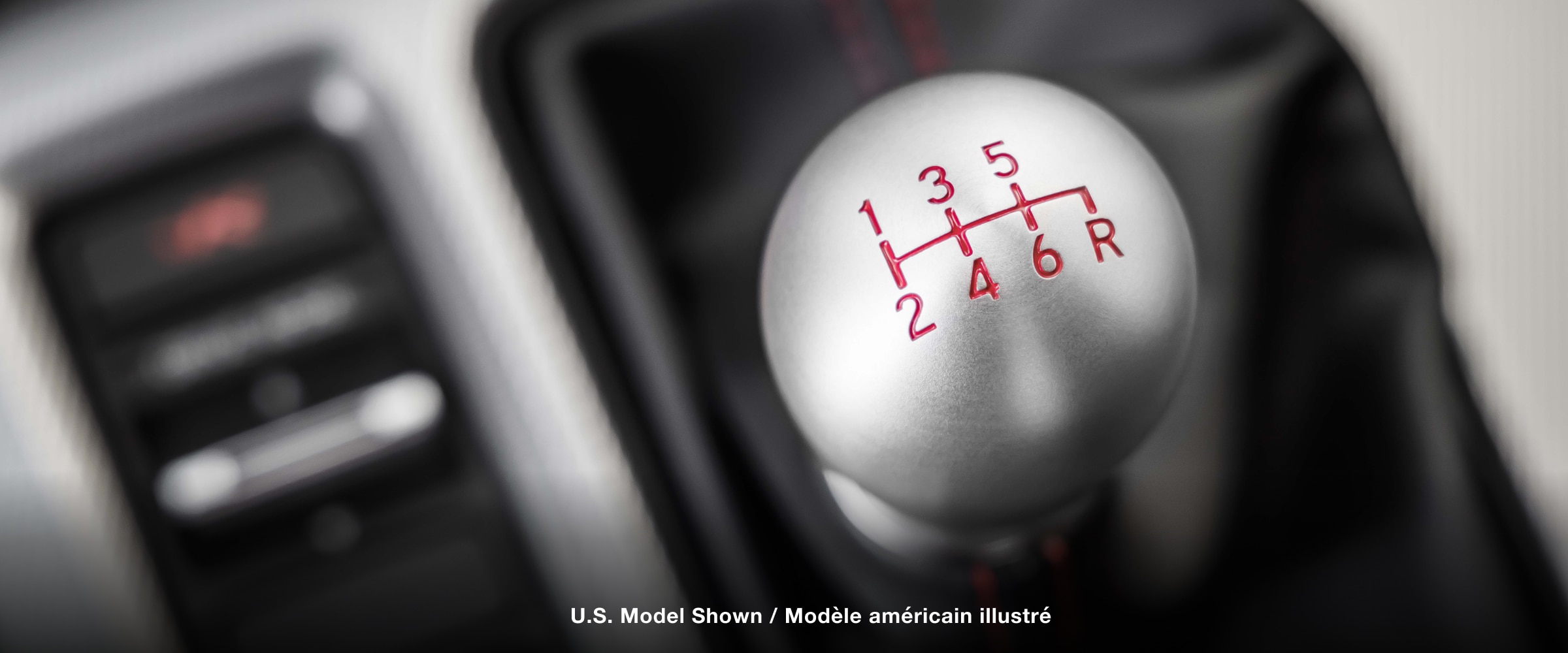 Extreme closeup of top of shifter, displaying the engraved gear map.