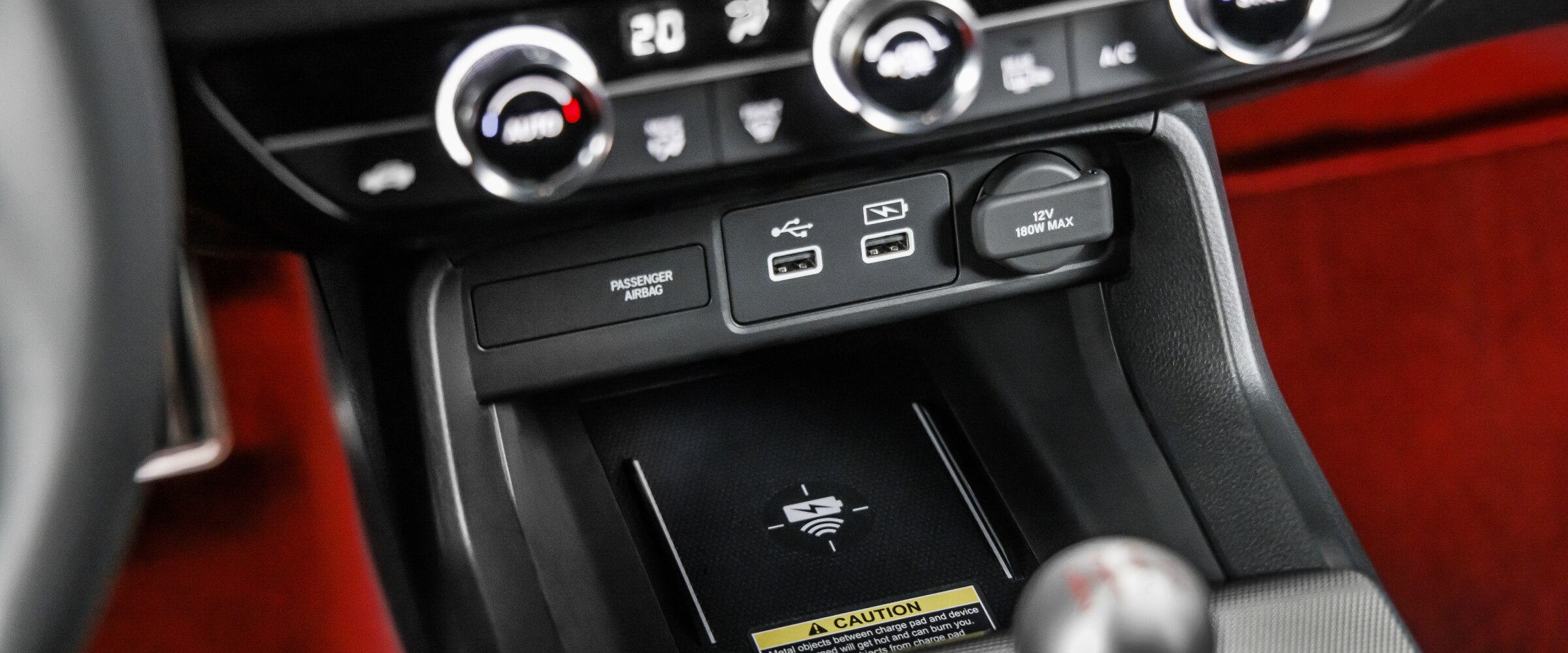 Gros plan du tapis de recharge sans fil dans la console centrale, au-dessus du levier de vitesses.