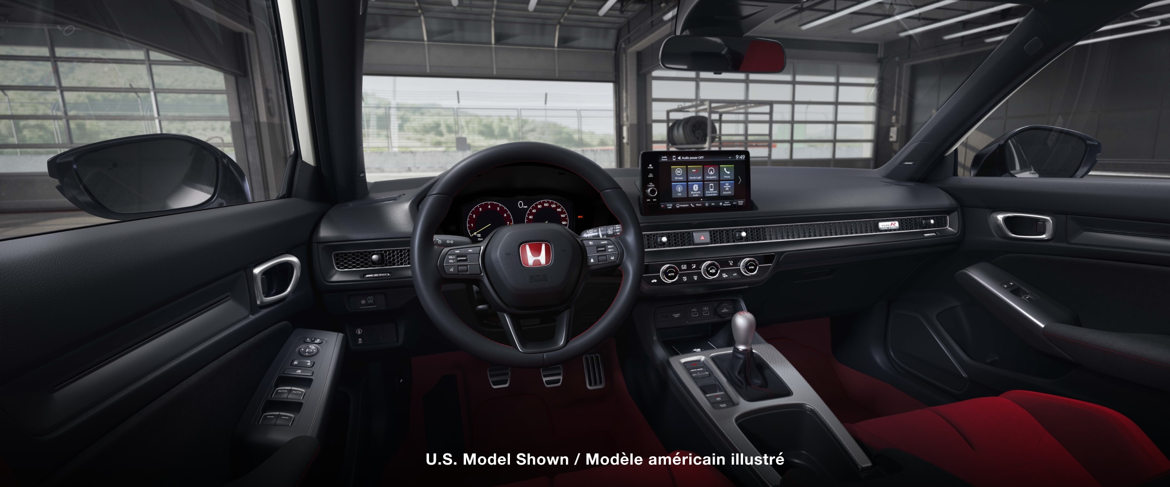 Panoramic view of steering wheel and front dashboard. Out the windshield, we see an open racing garage door.