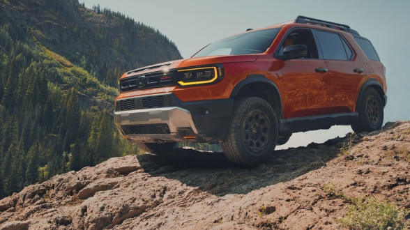 "Vue de trois quarts avant d'un Passport orange en tout-terrain dans le désert. "