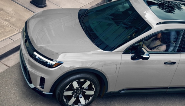 3/4 bird’s eye view of the front of a grey Prologue parked curbside in the city.