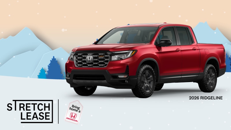A red 2026 Ridgeline Trailsport with snowy mountains and trees in the background.