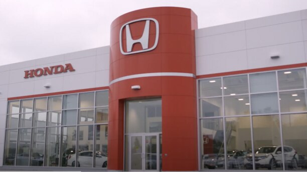 External picture of Honda dealership building and entrance./ Image extérieure du bâtiment et de l'entrée d’un concessionnaire Honda