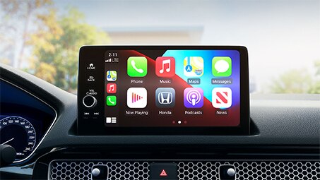 Vue rapprochée d'une tablette dans le cockpit d'une Honda avec plusieurs applications affichées à l'écran.