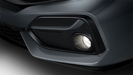 Vue agrandie de l'avant d'une Honda grise et d'un feu antibrouillard en bas à droite.