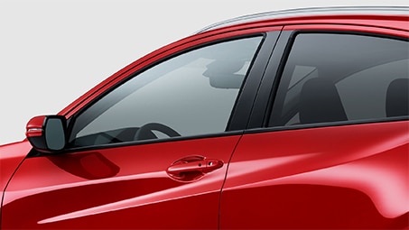 Cropped side-view of the front of a red Honda set against a white background.