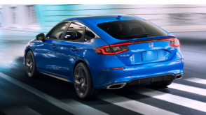 Plan rapproché de trois quarts d’une Civic à hayon bleue sur une rue urbaine bien éclairée la nuit.