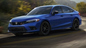 Vue latérale avant de trois quarts d’une Civic Si bleue effectuant un virage sur une autoroute de montagne.