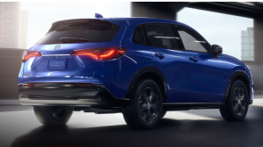 Plan de trois quarts arrière d’un HR-V bleu roulant dans un garage vide.