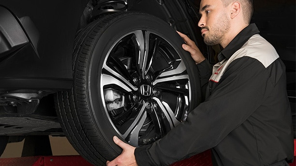 A certified Honda technician adjusting the installation of a genuine Honda tire. // Un technicien Honda certifié ajustant l'installation d'un pneu Honda d'origine.