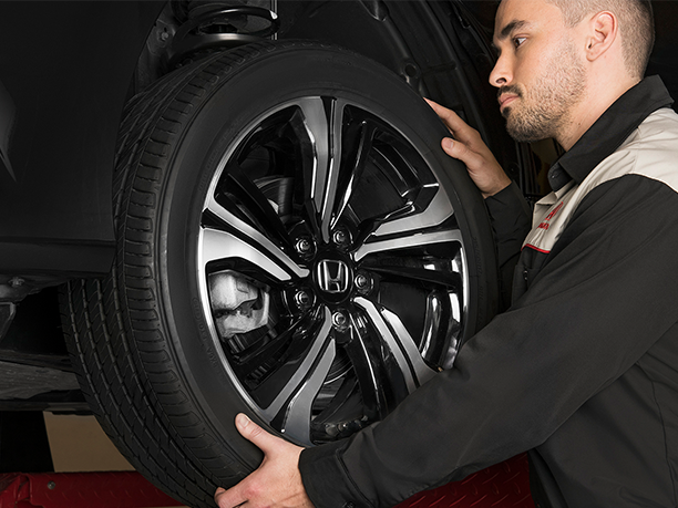 A certified Honda mechanic inspecting the Honda vehicle. // Un mécanicien Honda certifié inspectant le châssis d'un véhicule Honda.