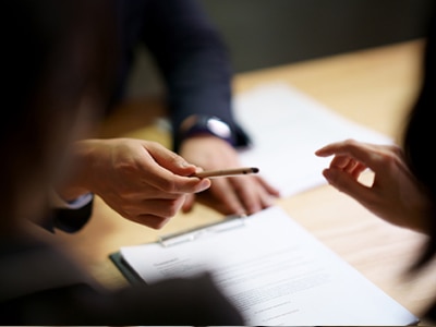 An Honda salesperson passing a pen to a customer to sign a document. // Un vendeur Honda passant un stylo à un client pour signer un document