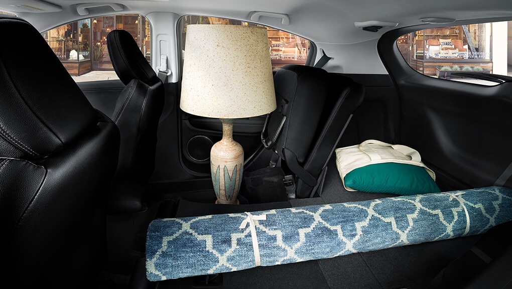 Interior view of the 2022 Honda HR-V, with rear seat folded down, storing a lamp and rug. 