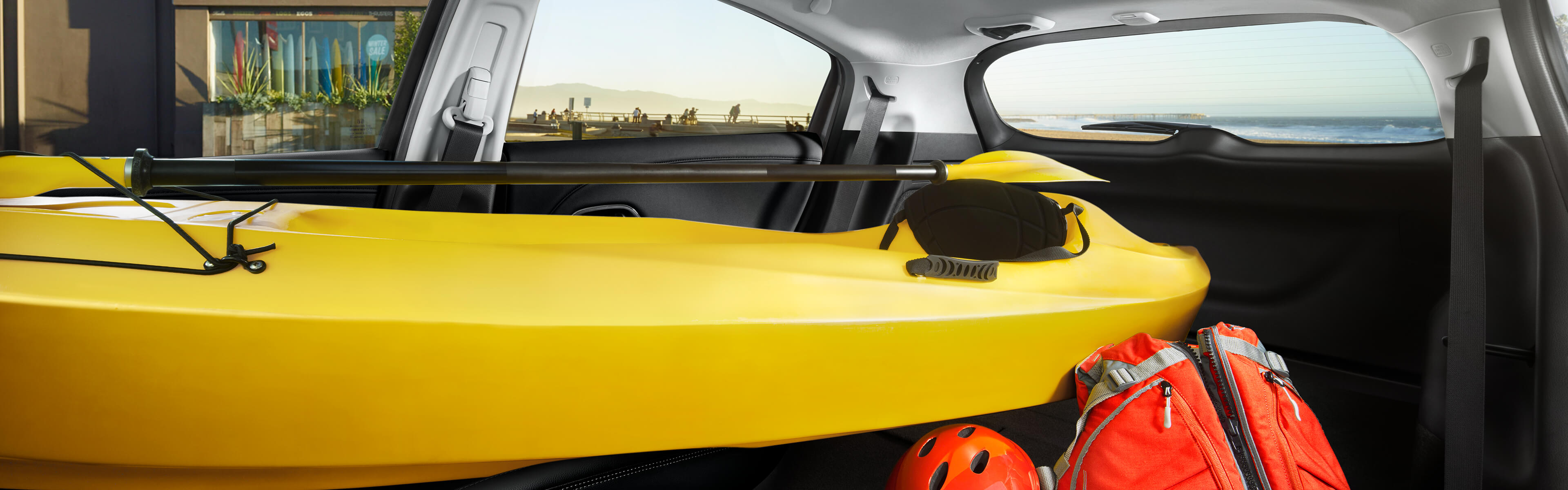 Vue intérieure du Honda HR-V 2022, avec tous les sièges arrière et le siège du passager rabattus pour ranger un kayak et des bagages. 