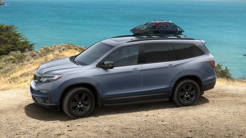 2022 Honda Pilot Trailsport parked on scenic beach with accessory roof box.