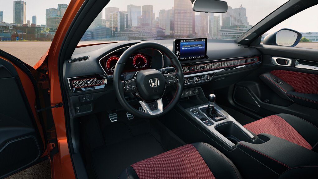 A look inside the driver’s door of a red Civic Si showing its many comforts & convenience