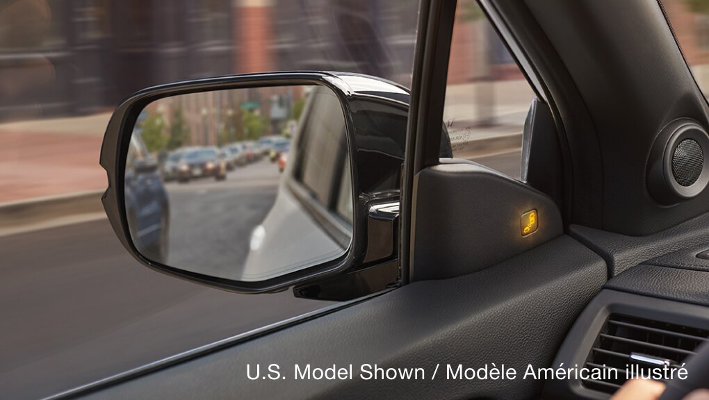 Interior view of 2022 Honda Passport driver’s side mirror and Blind Spot Information (BSI) system.
