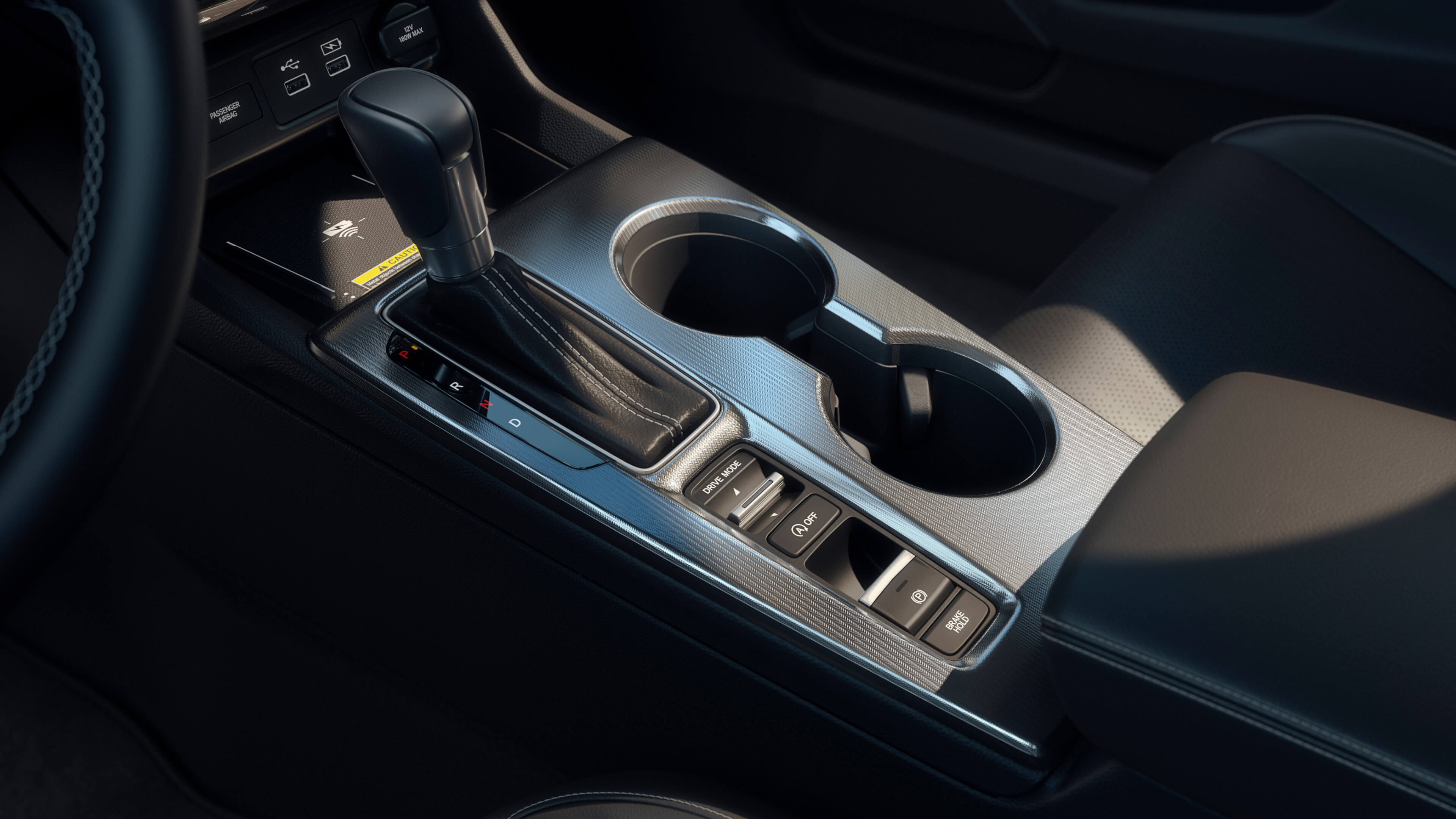 Close-up image of the centre console in a 2022 Honda Civic, including shifter, cup holders, arm rest and front tray.