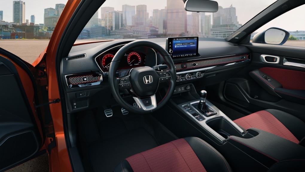 Intérieur de la porte côté conducteur d’une Civic Si rouge qui témoigne de son confort et de sa commodité.