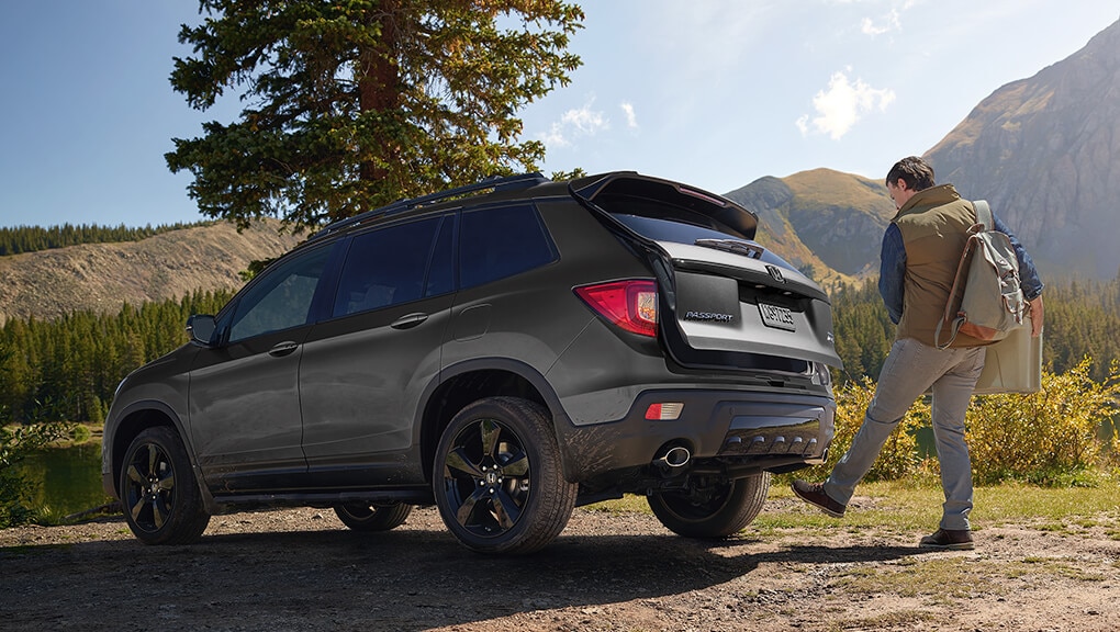 Rear 3/4 view of 2021 Honda Passport being opened via the available hands-free power tailgate.